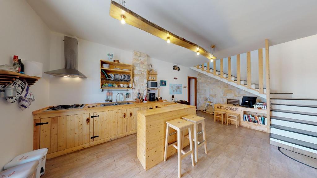 una cucina con armadi in legno, tavolo e sedie di Kite House Marsala Stagnone a Marsala