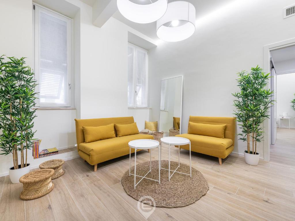 uma sala de estar com dois sofás amarelos e uma mesa em Maison Galilei - City Centre em Cagliari