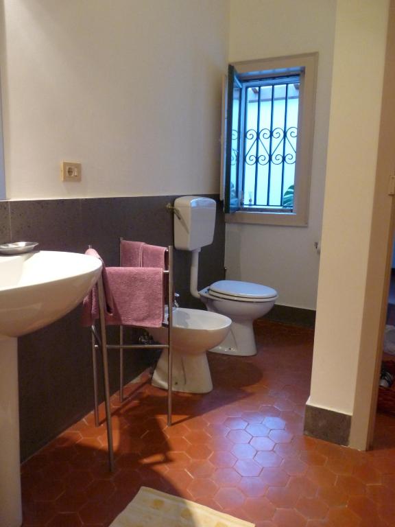 łazienka z umywalką, toaletą i oknem w obiekcie La Durlindana B&B w mieście Acireale