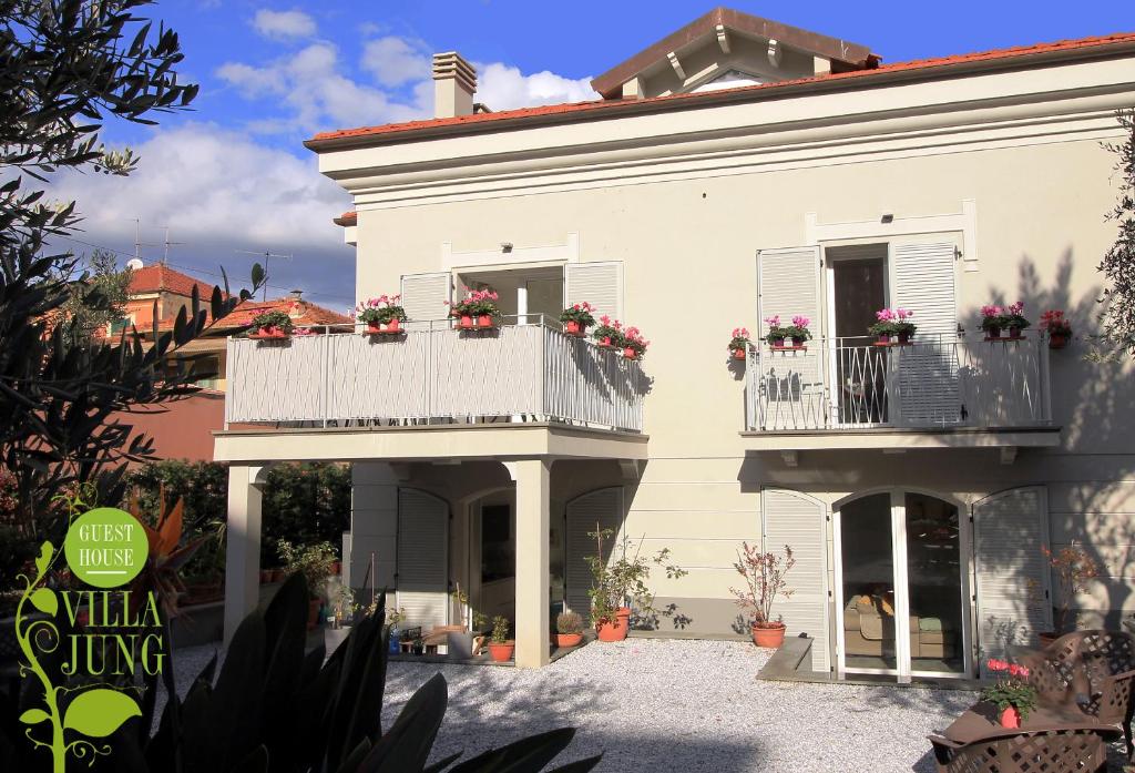a white house with flower boxes on the balconies at Guesthouse Villa Jung in Bordighera