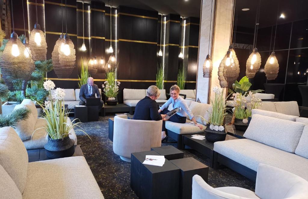 a group of people sitting in a lobby at Le Grand Hôtel Le Touquet-Paris-Plage in Le Touquet-Paris-Plage