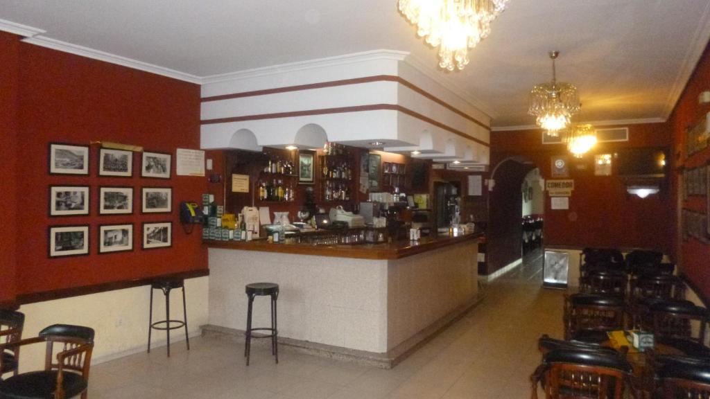 a restaurant with a bar with stools in a room at Hostal Cerezo in Guadalupe