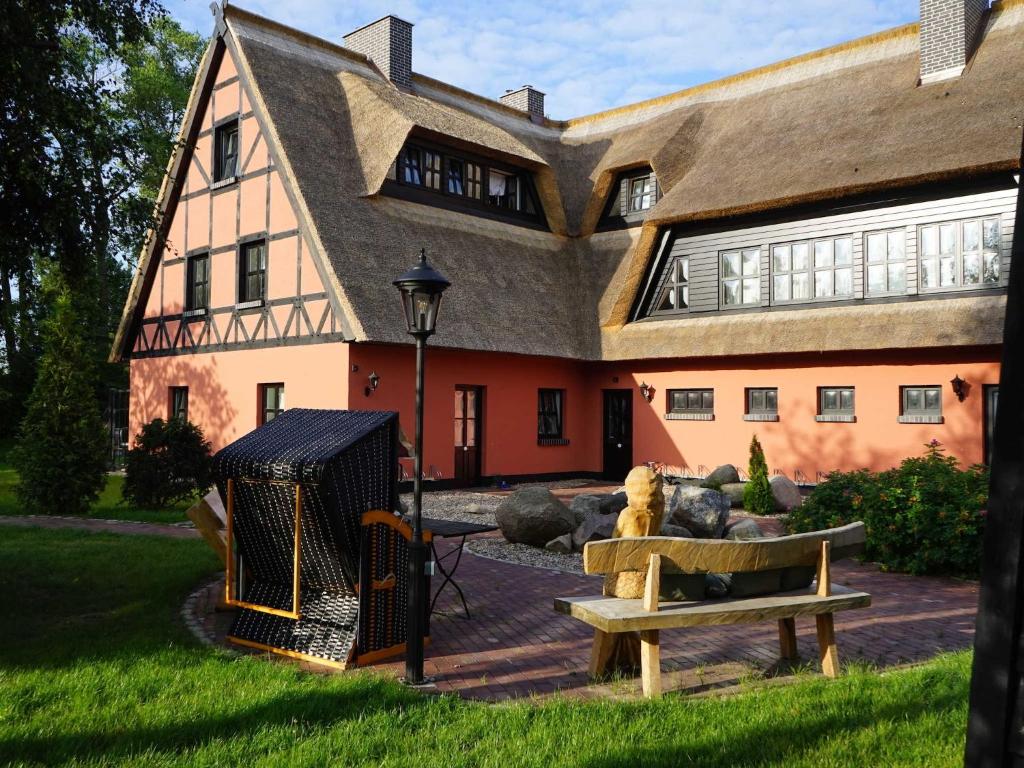 a house with a bird cage and a bench in front of it at Pferdehof Bela in Nonnevitz