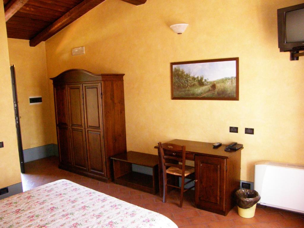 Crescentino的住宿－葛萊皮農家樂，一间卧室配有书桌、一张床和一个橱柜