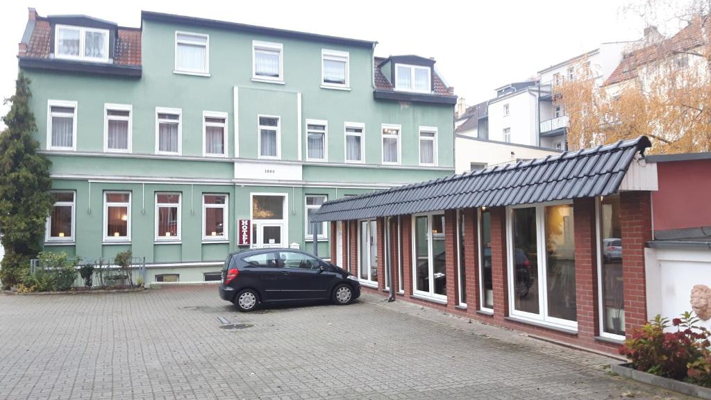 a car parked in a parking lot in front of a building at Hotel & Pension Plagwitzer Hof in Leipzig