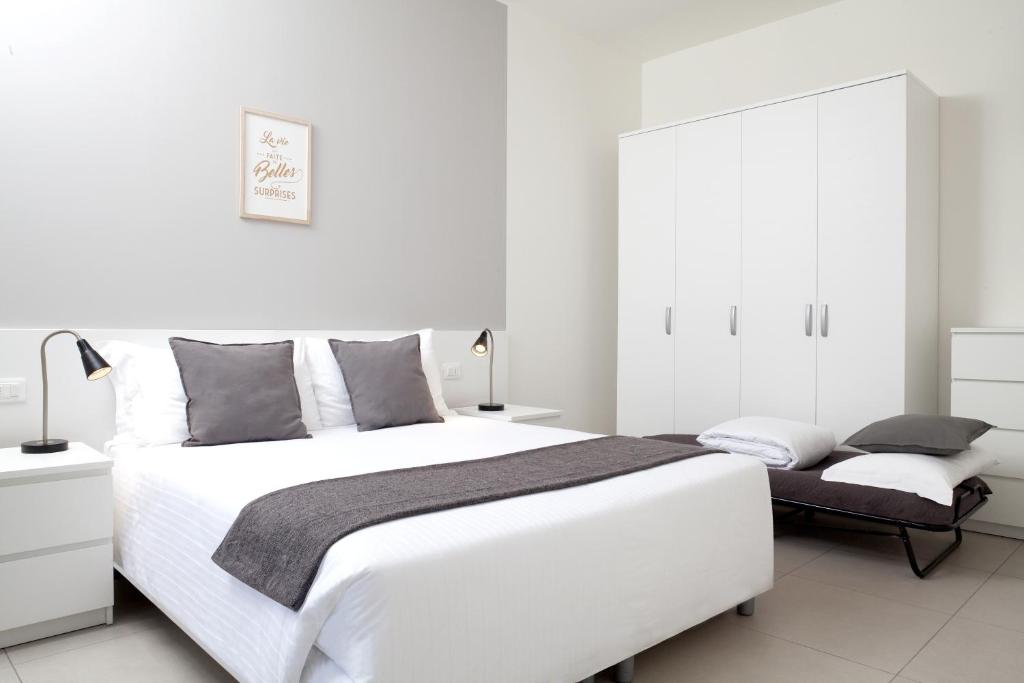 a white bedroom with a large bed and white cabinets at Palazzo Talenti 1907 in Trieste