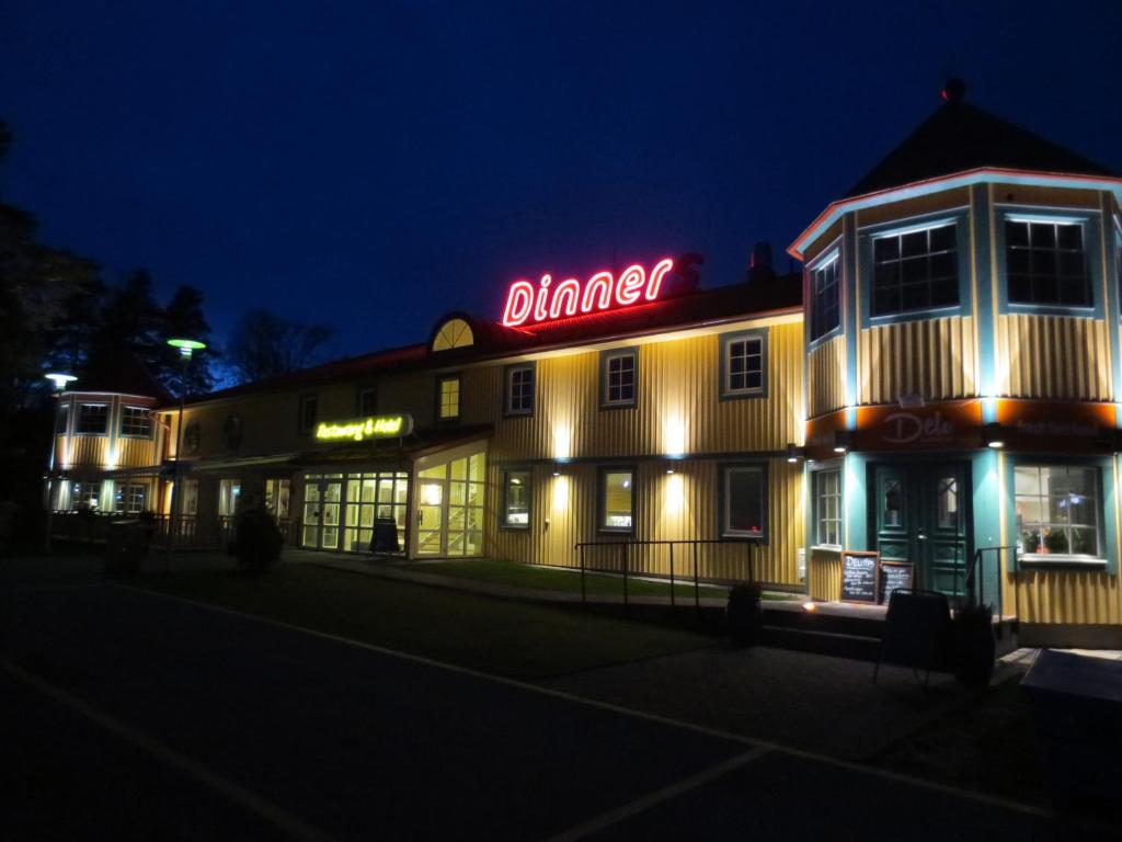 um edifício de jantar à noite com um sinal de néon em Dinners em Arboga