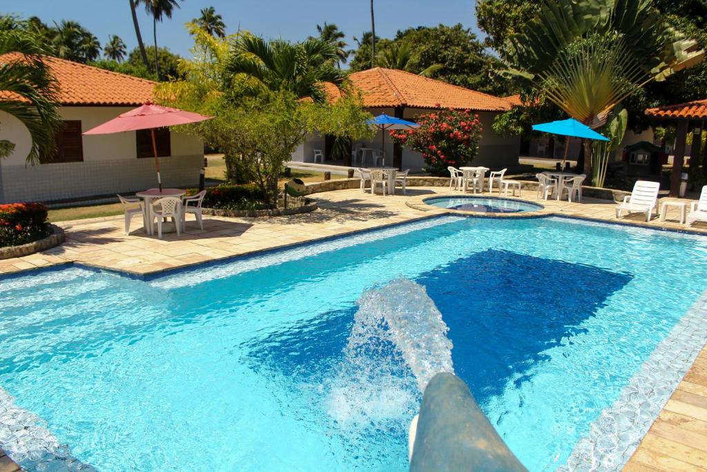 a swimming pool with a water fountain at Village Miramar in Maragogi