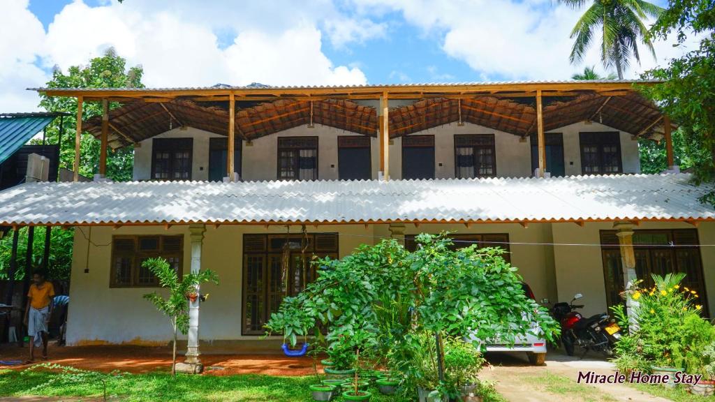 a house with a wooden roof on top of it at Miracle Home Stay in Dambulla