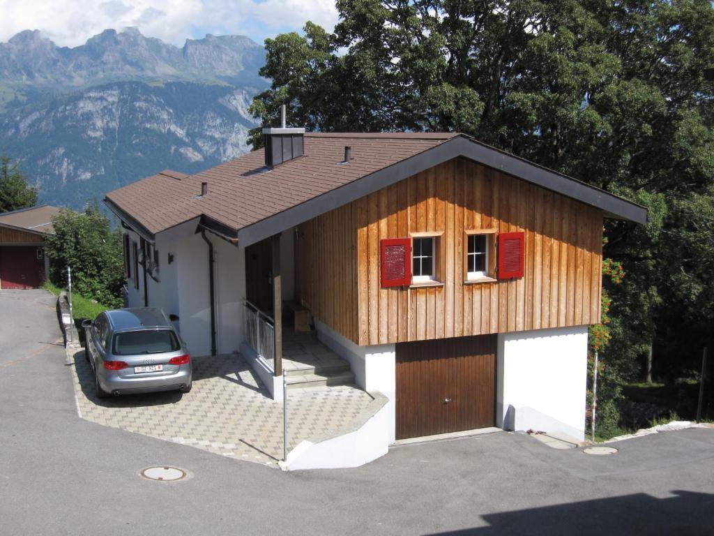 una casa con un coche aparcado delante de ella en Ferienhaus Ahorn, en Flumserberg