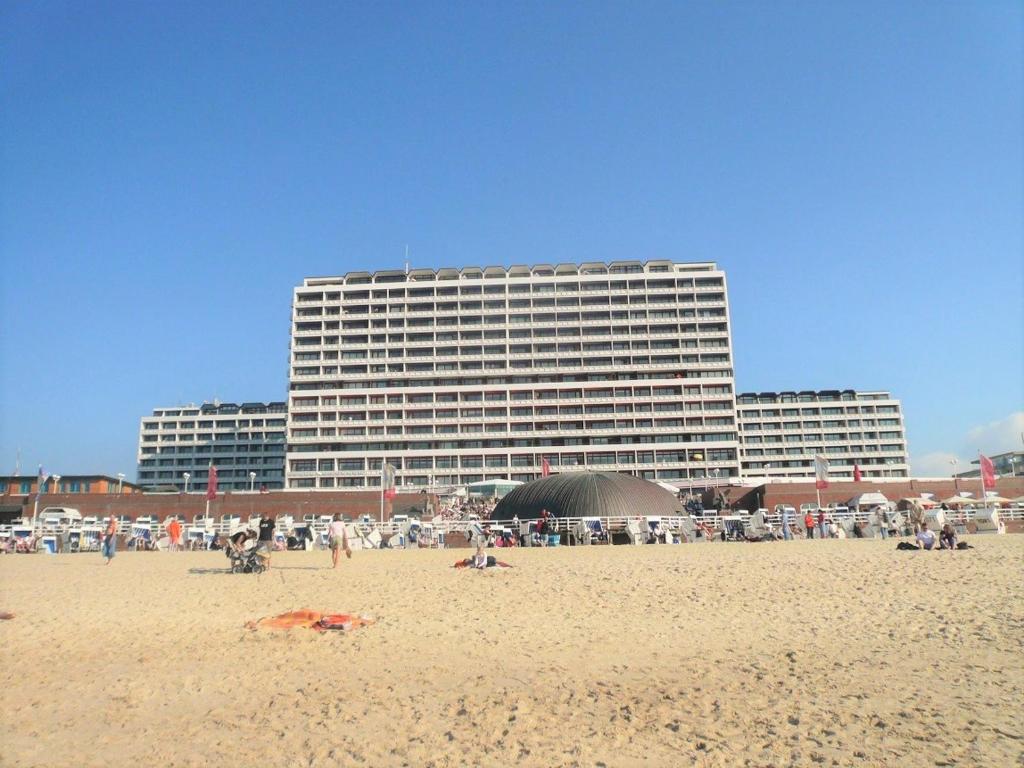 un groupe de personnes sur une plage avec un bâtiment dans l'établissement Haus Metropol - App. 234 SWB, à Westerland
