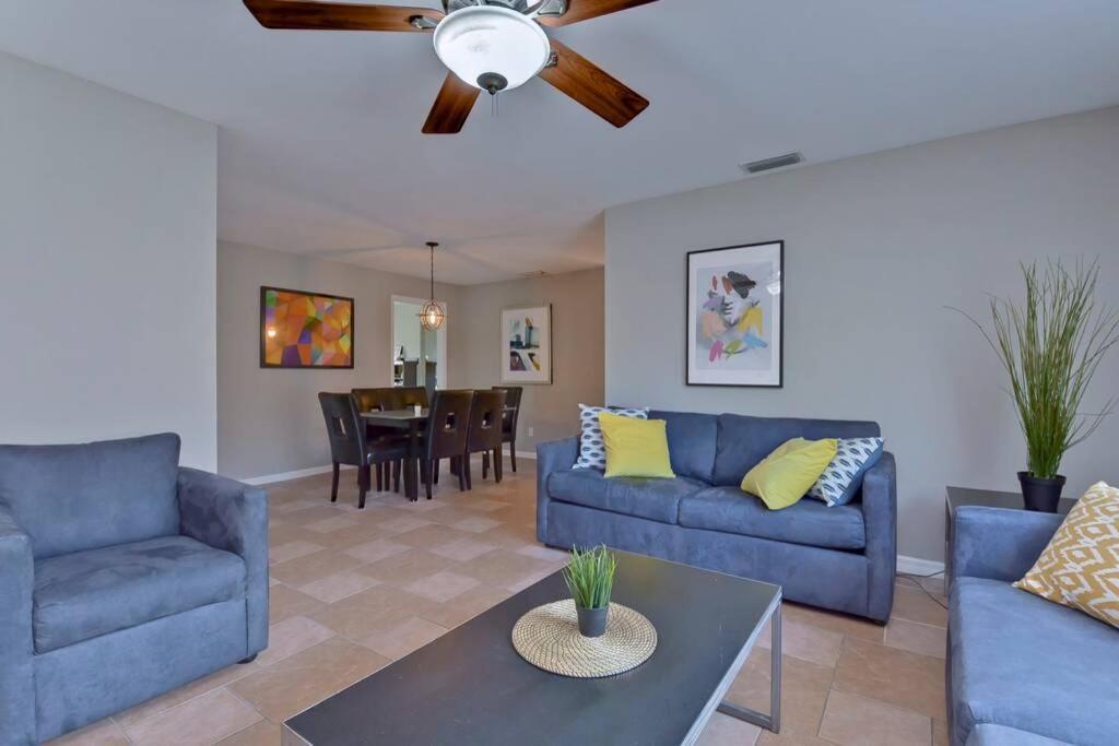 a living room with blue couches and a dining room at Ybor Casita! Steps away from Centro Ybor! in Tampa