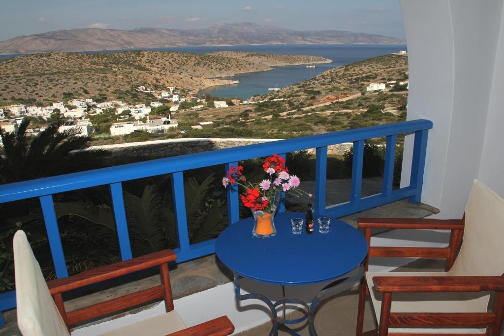 una mesa azul con un jarrón de flores en el balcón en Aiolos Hotel, en Iraklia