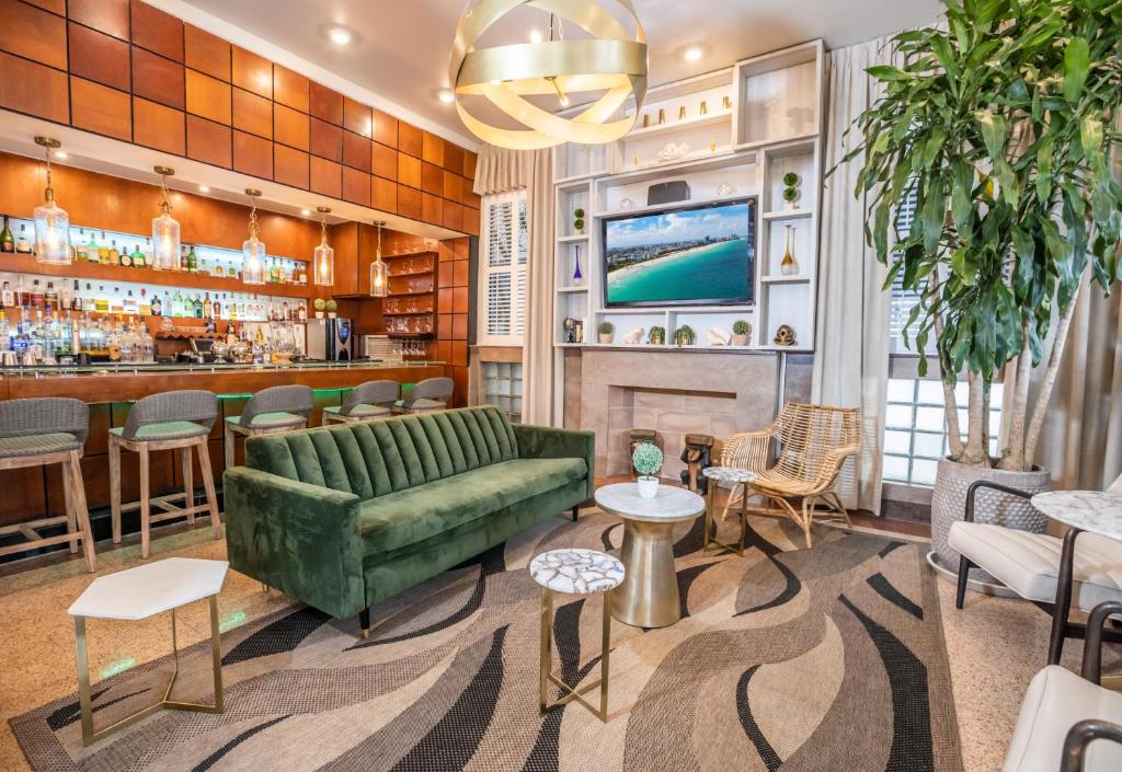 a lobby with a green couch and a bar at Chesterfield Hotel & Suites in Miami Beach