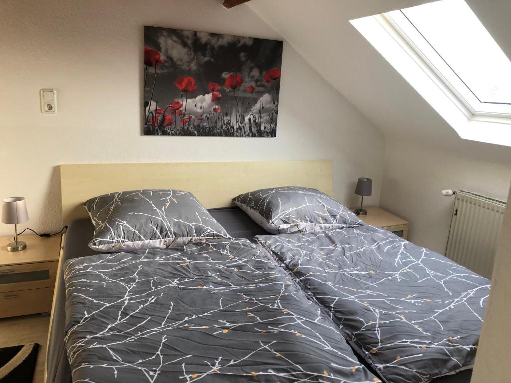 1 dormitorio con 1 cama con sábanas negras y flores rojas en Studio Apartment en Alsdorf
