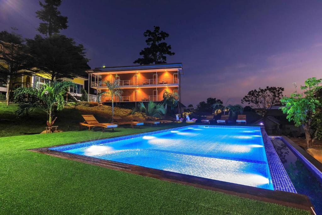 a swimming pool in front of a house at night at Phi Phi Chang Grand Resort in Phi Phi Islands