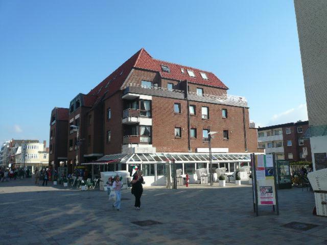 a man and a woman walking in front of a building at App. Hamelmann - mit kleinem Meerblick in Westerland