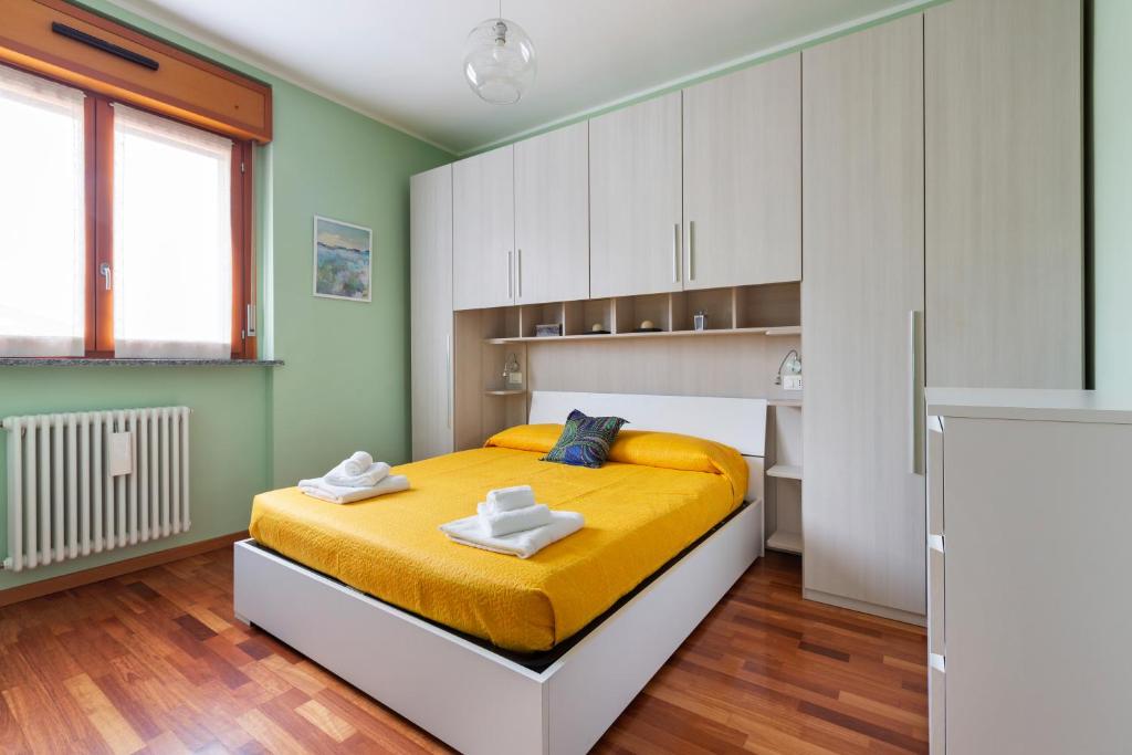 - une chambre avec un lit jaune et des armoires blanches dans l'établissement Savona District Terrace Flat, à Milan