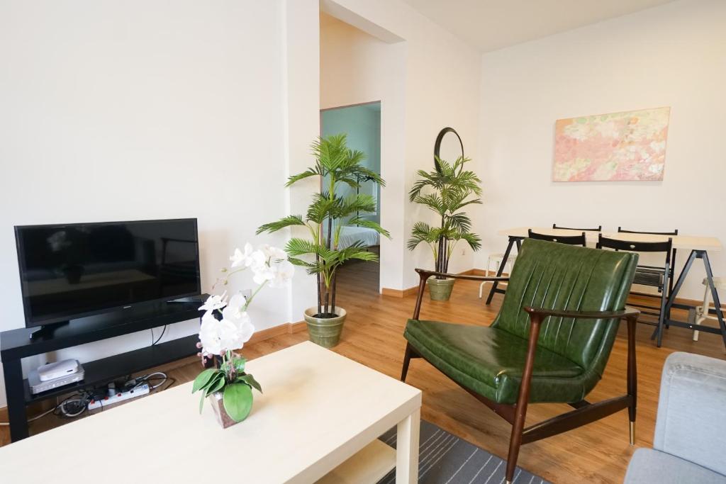 a living room with a tv and a green chair at IKO homes in Kota Kinabalu