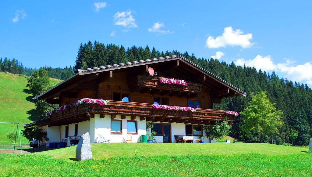 una casa en una colina con flores en el balcón en Gästehaus Einödberg en Mittersill