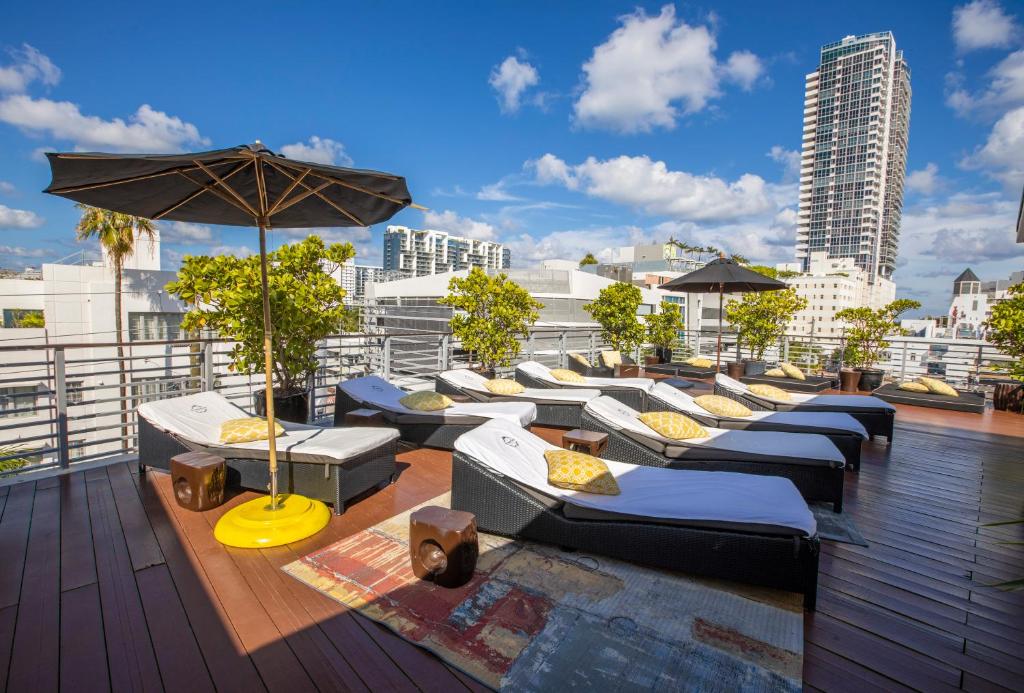 
a patio area with chairs, tables and umbrellas at Riviera Suites in Miami Beach
