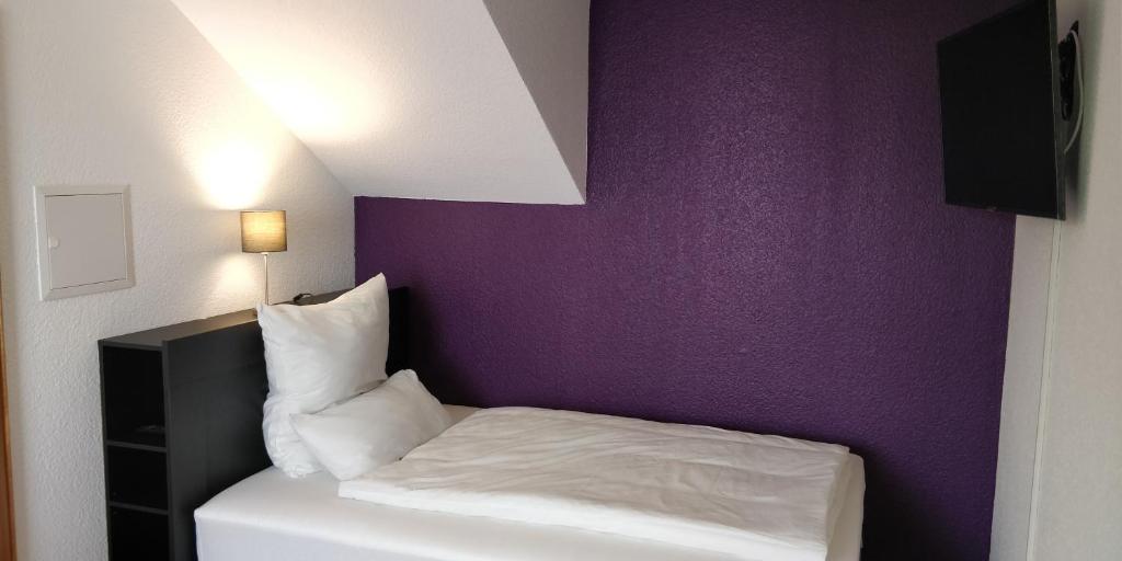 a bedroom with a bed with a purple wall at TH Exclusive in Düsseldorf