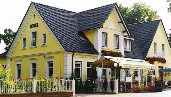 ein großes gelbes Haus mit schwarzem Dach in der Unterkunft Landhaus Tewel in Tewel