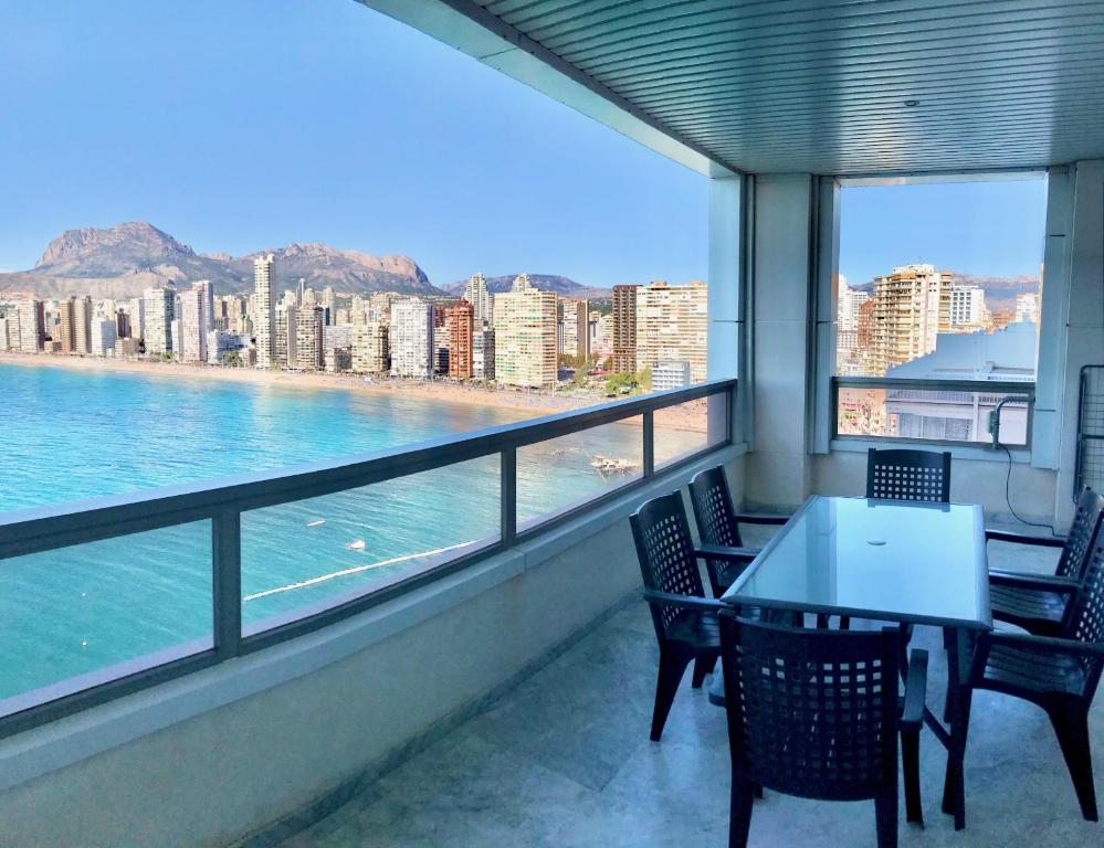 a balcony with a table and chairs and a view of the water at Gemelos 28 Blueline in Benidorm