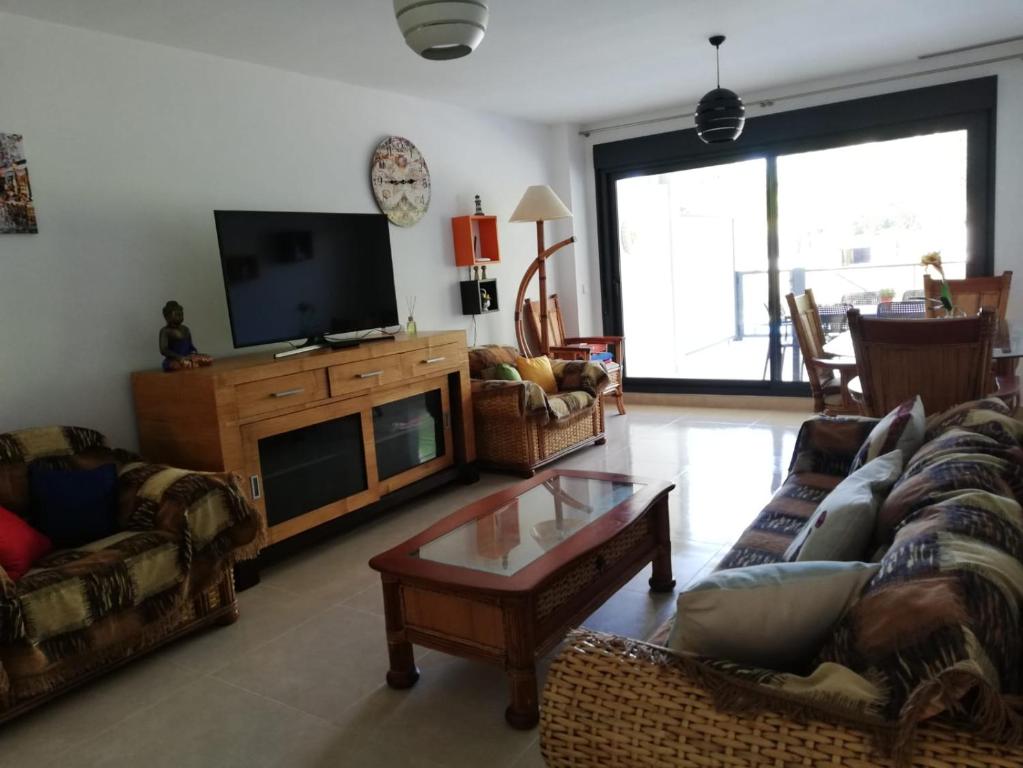 uma sala de estar com sofás e uma televisão de ecrã plano em Terrazas de las Marinas em Denia