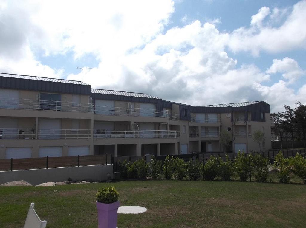 an apartment building with a lawn in front of it at villa marine 2 in Jullouville-les-Pins