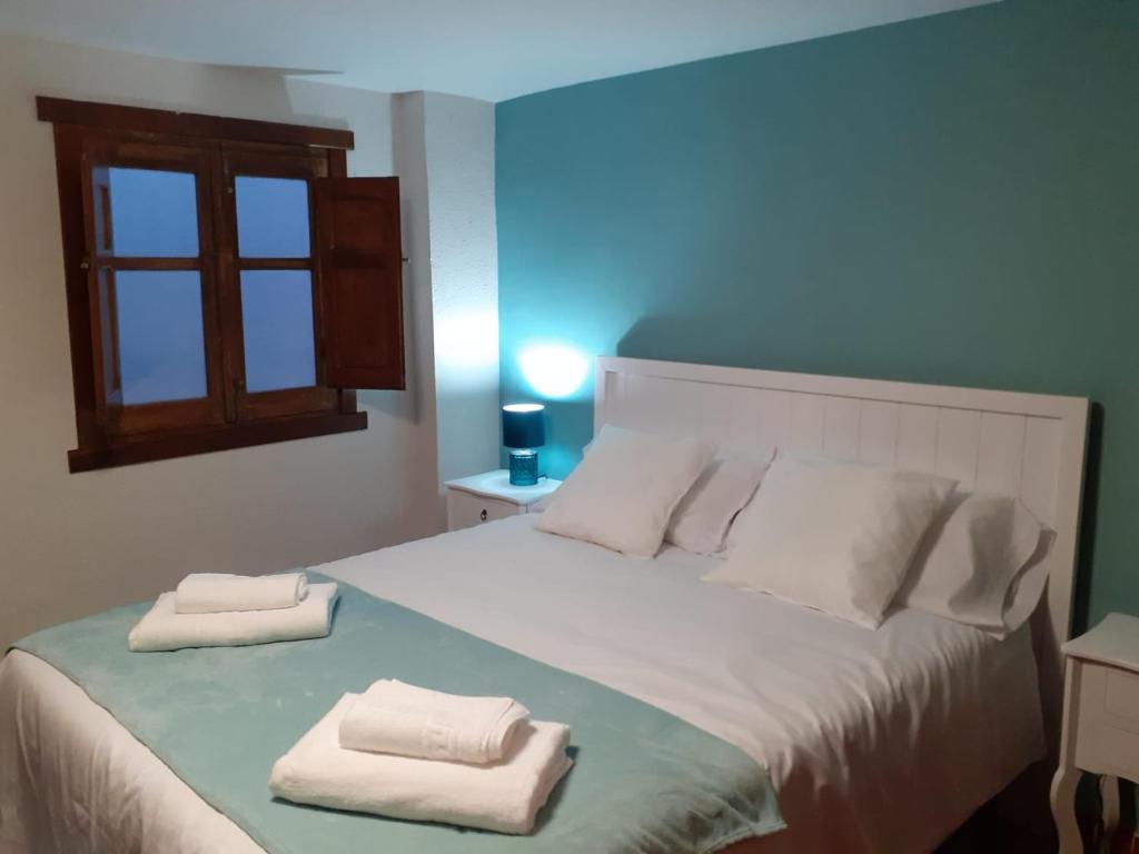 ein Schlafzimmer mit einem Bett mit zwei Handtüchern darauf in der Unterkunft La Calleja del Canchal in Arenas de San Pedro
