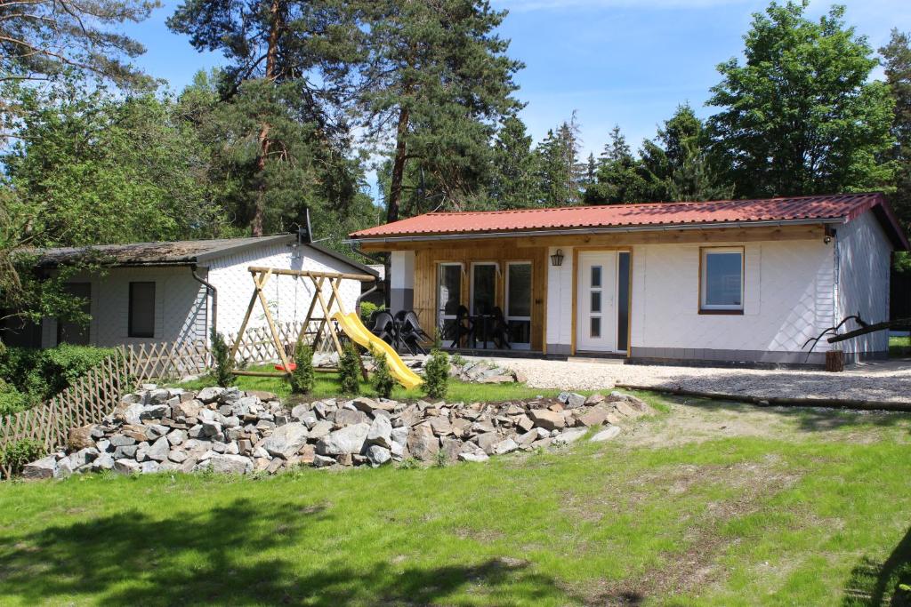 a small house with a playground in front of it at ZumSeehörnchen Haus Schmetterling in Tanna