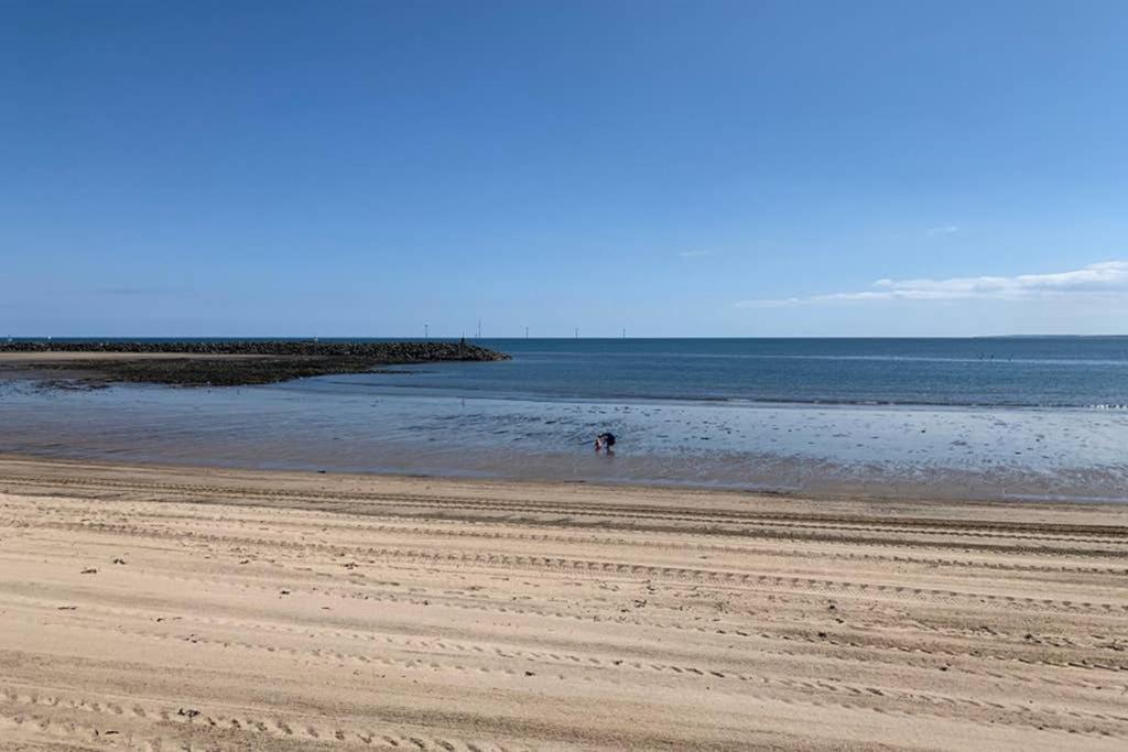 a person walking in the water on a beach at The Beach Loft in Newbiggin-by-the-Sea