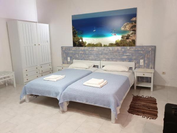 a bedroom with two beds and a painting on the wall at Hotel Finiki View in Foiníkion