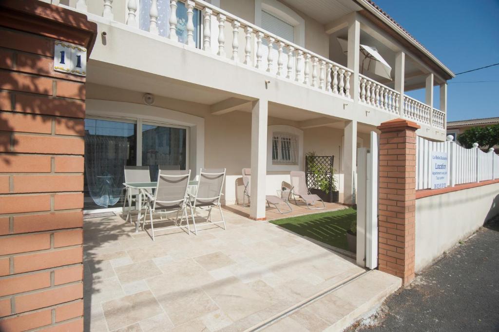 d'une terrasse avec des chaises et une table sur le côté de la maison. dans l'établissement La Belle Gruissanaise, à Gruissan