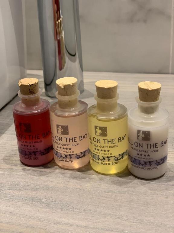 a group of four bottles of paint on a counter at Gull on the Bay Boutique Guest House in Bloubergstrand