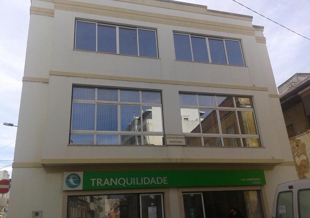 a tall white building with large windows on it at Edificio Lavadeiras in Olhão
