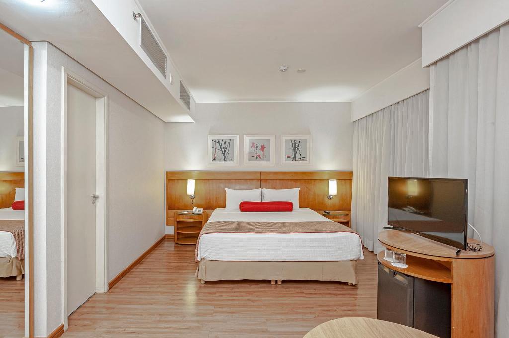 a hotel room with a bed and a flat screen tv at Slaviero São Paulo Moema in Sao Paulo