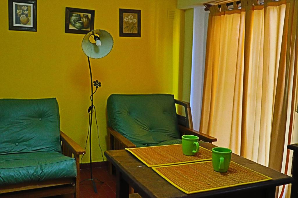 Una sala de estar con una mesa y sillas y una lámpara. en EDIFICIO CABO FRIO. I, en Pinamar