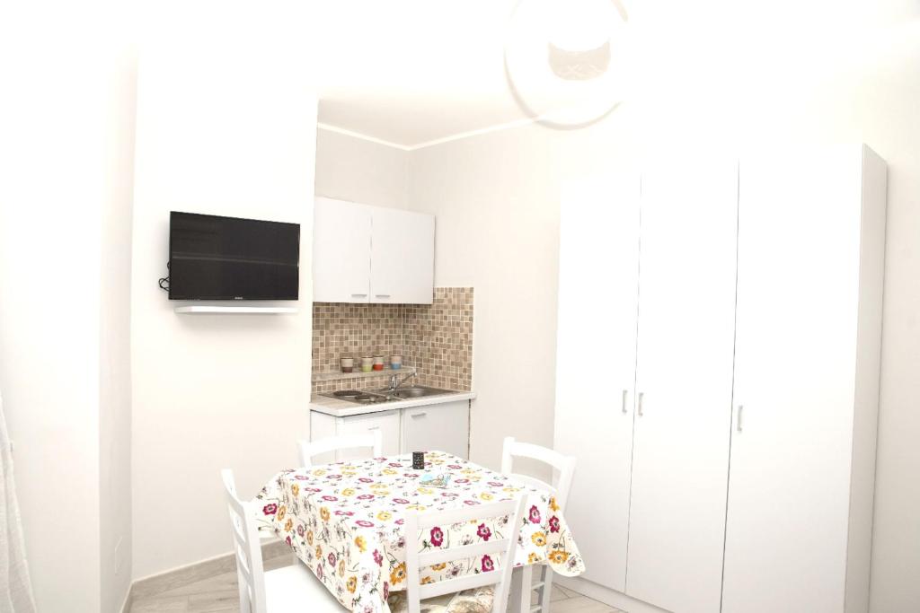 ナポリにあるOne bedroom apartement with wifi at Napoliの白いキッチン(テーブル、椅子付)