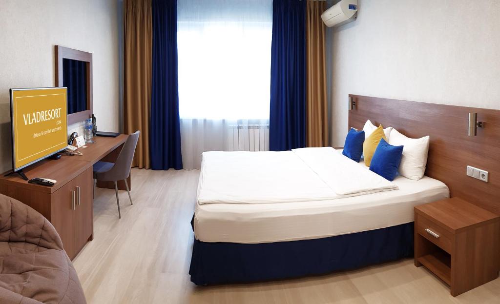 コヴロフにあるOLIMPIA DeLuxeの大きなベッドとデスクが備わるホテルルームです。