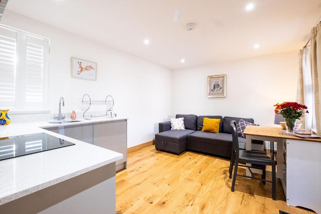 a kitchen and living room with a couch and a table at Three Tuns Apartments - Sycamore in Pettistree