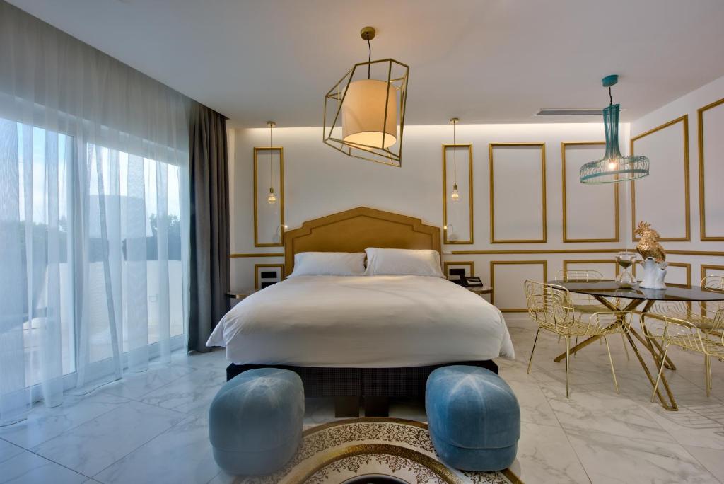a bedroom with a large bed and a table at HOLM Boutique & SPA - IK Collection in St. Julianʼs