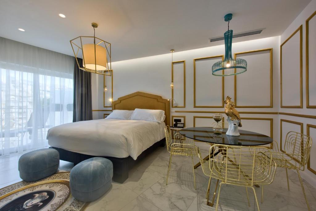 a bedroom with a bed and a table and chairs at HOLM Boutique & SPA - IK Collection in St. Julianʼs