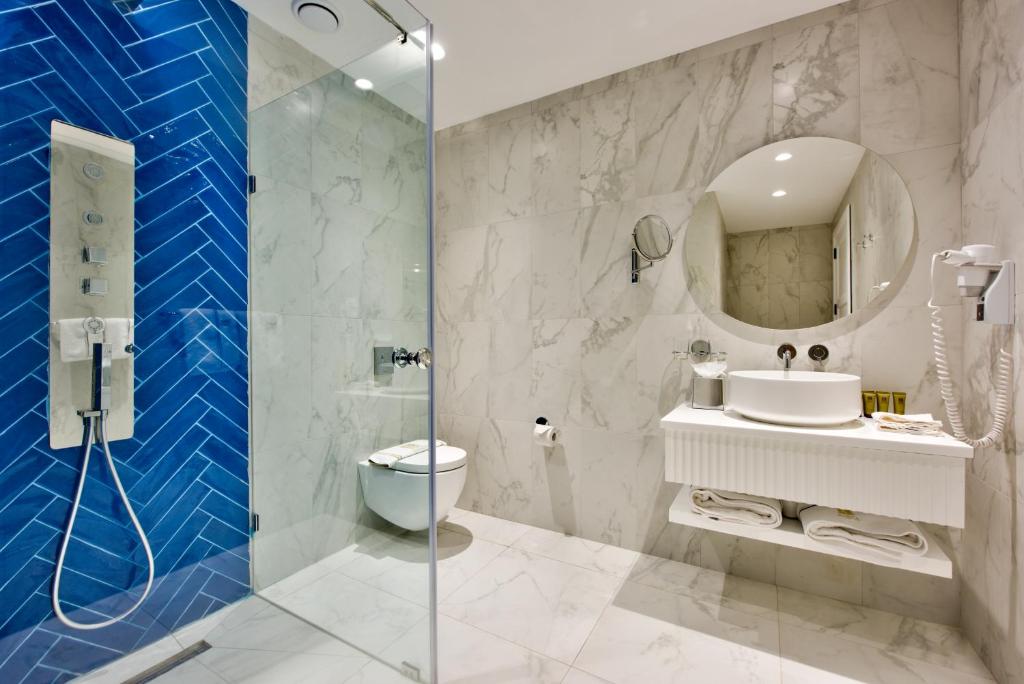 a bathroom with a toilet and a sink and a shower at HOLM Boutique & SPA - IK Collection in St. Julianʼs