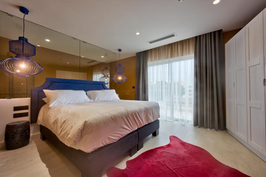 a bedroom with a large bed and a large window at HOLM Boutique & SPA - IK Collection in St. Julianʼs