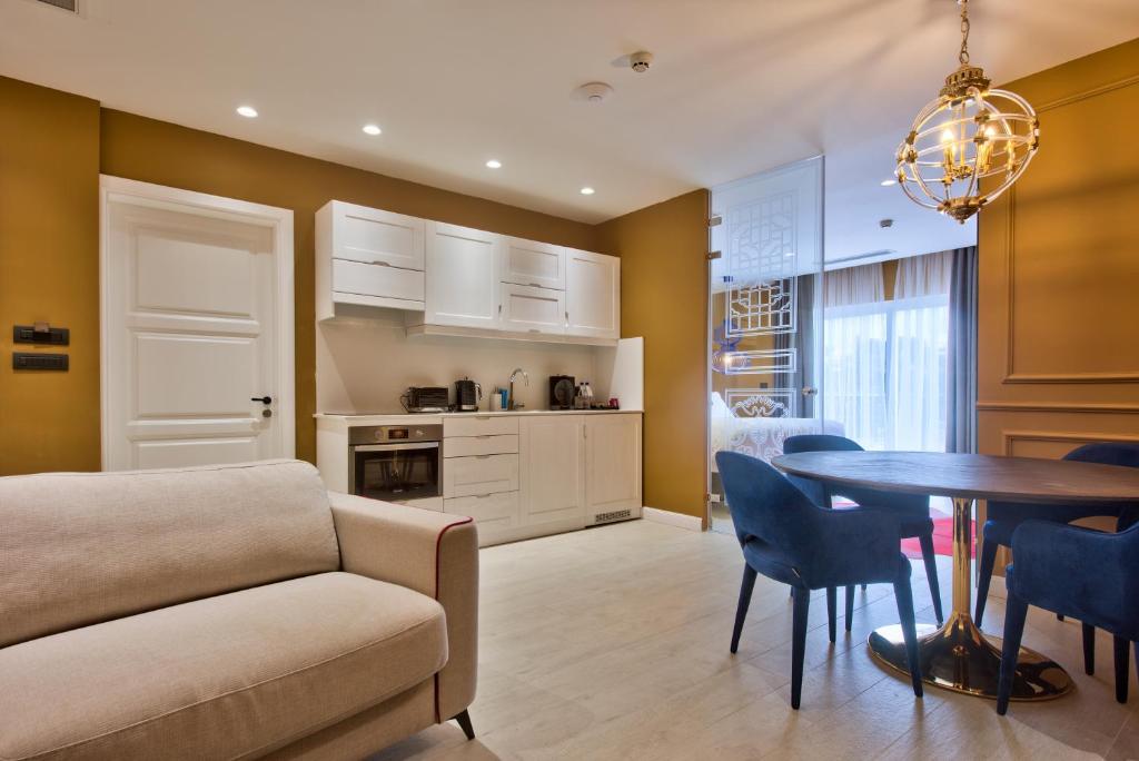 a living room with a couch and a table with chairs at HOLM Boutique & SPA - IK Collection in St. Julianʼs