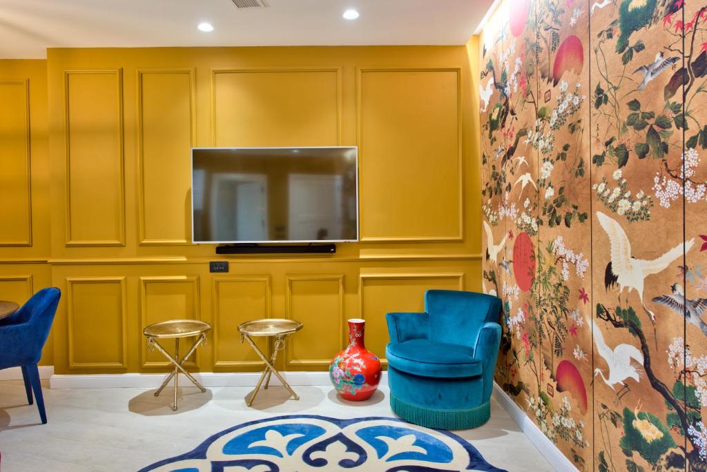 a living room with yellow walls and a tv at HOLM Boutique & SPA - IK Collection in St. Julianʼs