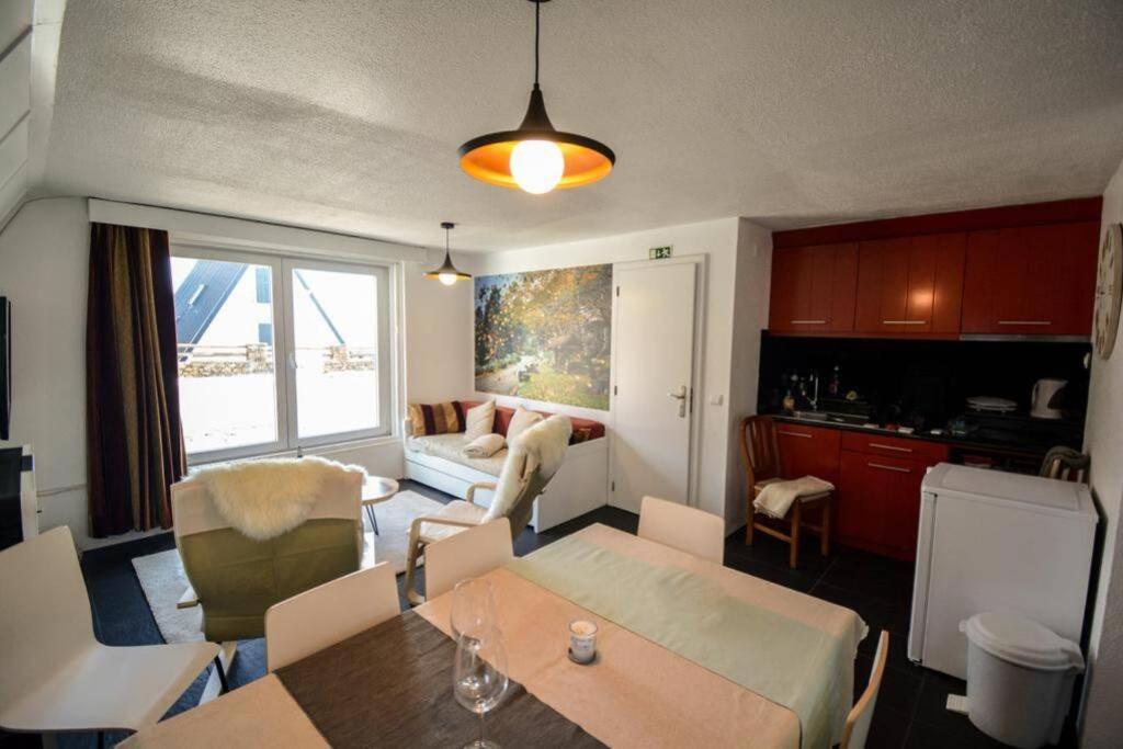 a kitchen and living room with a table and chairs at Chalé Acolhedor - Penhas da Saúde - Serra da Estrela in Covilhã