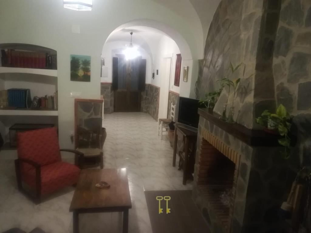 uma sala de estar com lareira e um sofá e uma cadeira em CASA VASCO em Jerez de los Caballeros